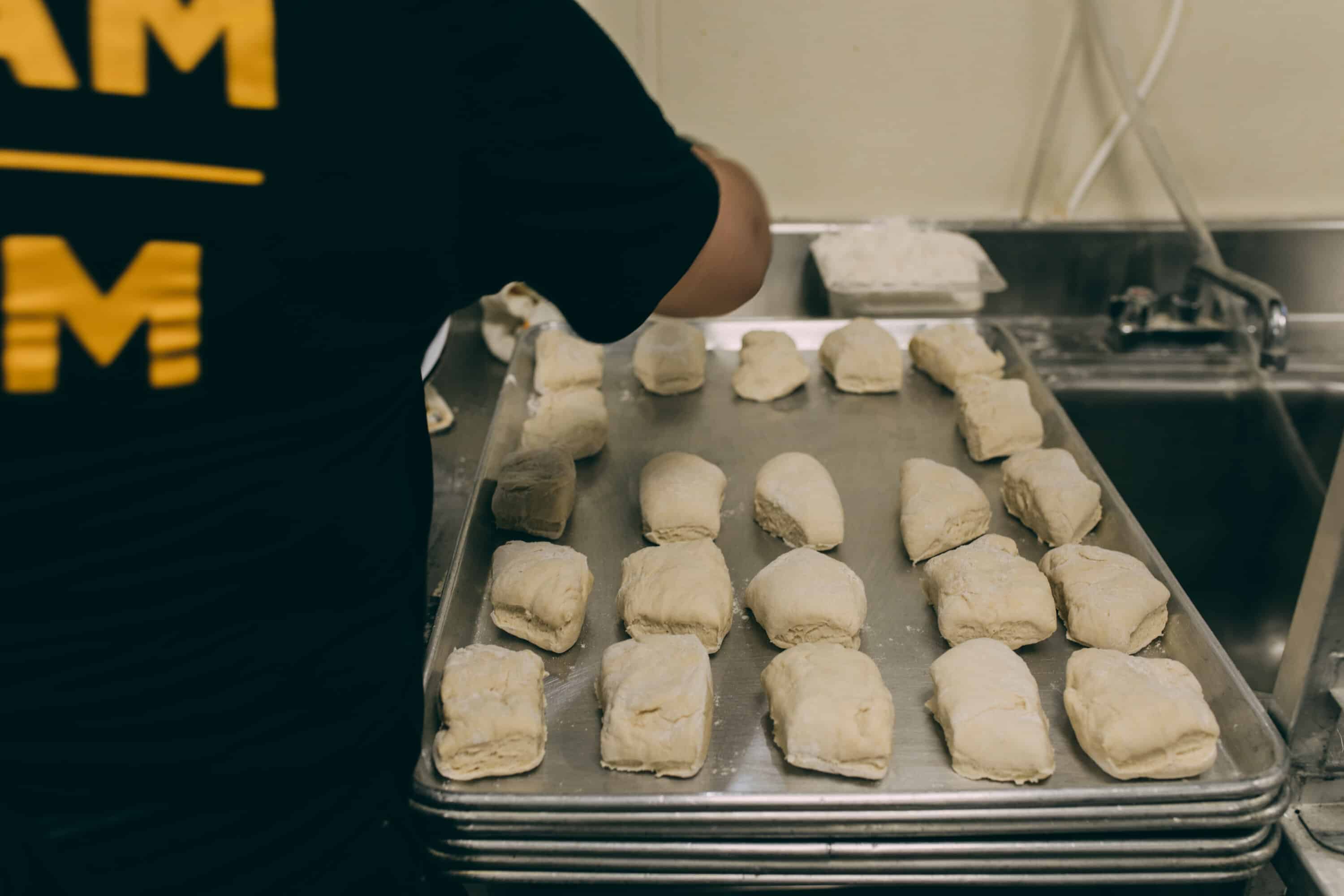 PREAM team member rolling dough for cinnamon rolls
